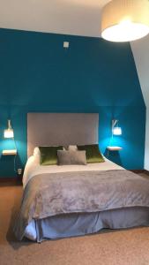 1 dormitorio con 1 cama grande y pared azul en Le Clos Gaillardou, en La Roque-Gageac