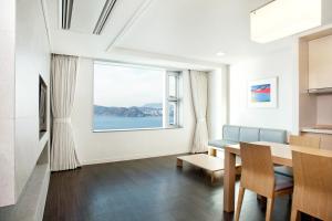 a dining room with a table and a large window at Hanwha Resort Haeundae in Busan