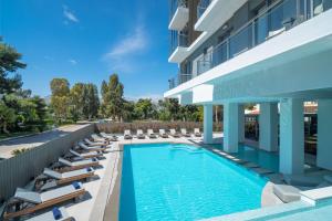 an image of a hotel swimming pool with lounge chairs at Glyfada Riviera Hotel in Athens