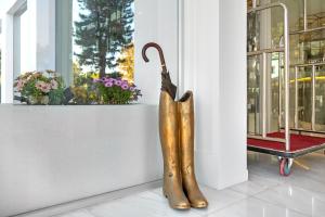 a statue of a pair of boots next to a window at Glyfada Riviera Hotel in Athens
