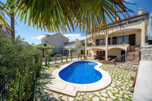 una villa con piscina di fronte a una casa di Nomad Luxury Villa a Vodice