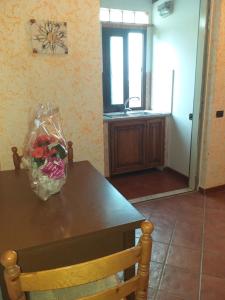 阿爾代亞的住宿－Mirella's House ViaVerona，厨房里摆放着一张桌子,上面放着一束鲜花