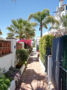 una pasarela entre casas y palmeras en Bella Jacaranda en Marbella