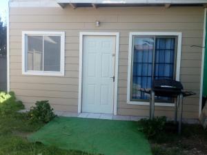 埃尔基斯科Cabaña tablaqui的一间设有白色门和烧烤架的房子