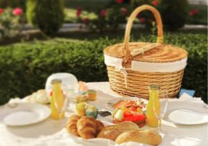 een picknicktafel met een mand met brood en sap bij La Perla Blanca - Ronda in Ronda