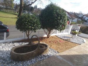 a statue of a bird in a yard with two trees at Villa Rue Gainekoa in Cambo-les-Bains