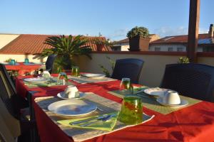 - une table avec des assiettes et des serviettes sur une terrasse dans l'établissement S'Apprigu B&B, à Cabras