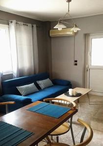 ein Wohnzimmer mit einem blauen Sofa und einem Tisch in der Unterkunft Lemontree in Athen