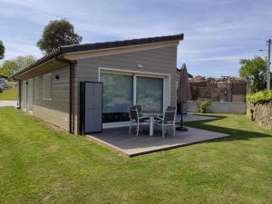 a shed with a table and chairs in a yard at Apartamentos La Encina in Celorio