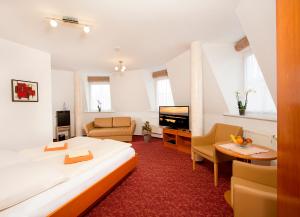 a bedroom with a large bed and a living room at Ferienhotel Bernstein in Trassenheide