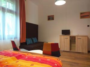 a living room with a bed and a couch at Balatonszemesi Nyaralóház in Balatonszemes