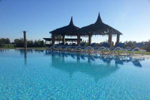 una gran piscina con sillas y cenador en Tenuta dei Principi, en Marina di Grosseto