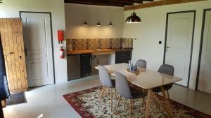 a kitchen with a table and chairs in a room at La Cour d'Enchère in Saint-Palais