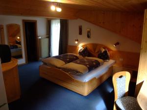 1 dormitorio con 1 cama grande de madera en una habitación en Garnì Conturina, en Santa Cristina Valgardena