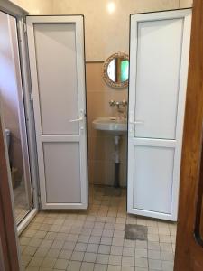 baño con 2 puertas correderas y lavamanos en Guest house Amza, en Ochamchira