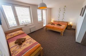 um quarto com 2 camas e 2 janelas em Penzion TOP em Cesky Krumlov
