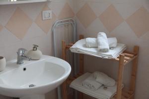 bagno con lavandino, servizi igienici e asciugamani di B&B Amèlie a Lecce