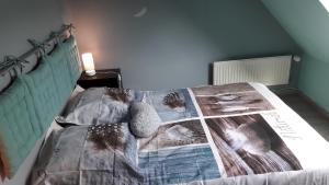 a bedroom with a bed with a blanket on it at ENFIN ! in Grandcamp-Maisy