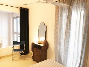 1 dormitorio con espejo, tocador y silla en Il Teatro en Scilla
