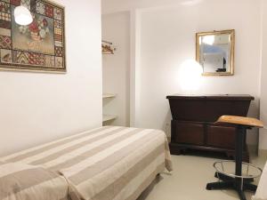 1 dormitorio con cama, tocador y espejo en Il Teatro en Scilla