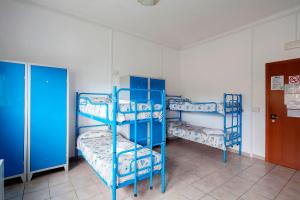 two blue bunk beds in a room with a door at Ostello Corniglia in Corniglia