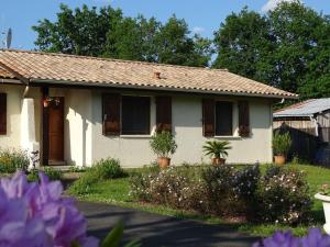 una casa blanca con flores delante en Gite Les Garbails, en Le Barp