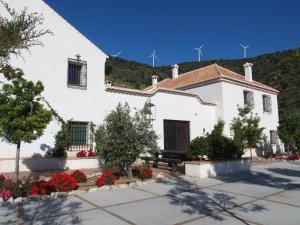 ein weißes Haus mit Blumen davor in der Unterkunft Cortijo Sancardo in Lújar