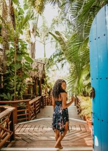 una mujer vestida caminando por una pasarela de madera en Tranquilseas Eco Lodge & Dive Center, en Sandy Bay