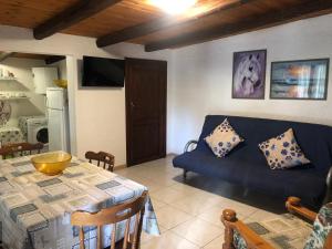 a living room with a blue couch and a table at Fleming 46 in Alghero