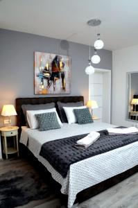 una camera con un grande letto e un dipinto sul muro di Apartments La Luna a Zara (Zadar)
