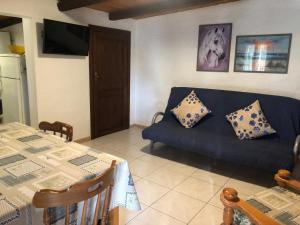 a living room with a blue couch and a table at Fleming 46 in Alghero