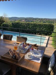 een tafel met eten en uitzicht op een zwembad bij Villa Chamarel in Carcès
