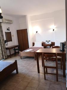 a bedroom with a bed and a table and chairs at Katerina Apartments in Stalida