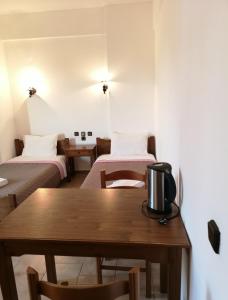 a room with two beds and a wooden table at Katerina Apartments in Stalís
