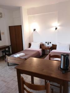 a hotel room with two beds and a table at Katerina Apartments in Stalís