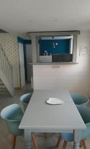 Ô Cosy في Longvilliers: طاولة بيضاء وكراسي زرقاء في الغرفة