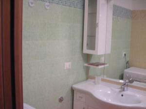bagno con lavandino, specchio e doccia di FARO TRILOCALE PIANO ATTICO a Lignano Sabbiadoro