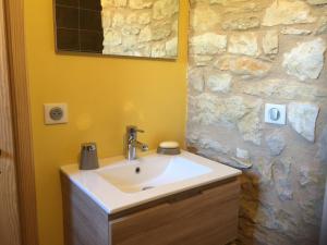 a bathroom with a sink and a stone wall at Domaine de Galoubet Lot in Beaumat
