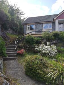 une maison avec des escaliers en face de celle-ci dans l'établissement The Black Sheep, à Glengarriff