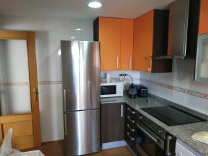 a kitchen with a stainless steel refrigerator and a microwave at 6 Calle las Tuerces in Aldeamayor de San Martín