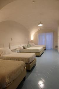 a group of three beds in a room at Hotel Baia Di Puolo in Massa Lubrense