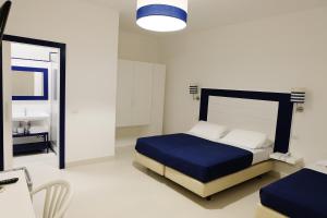 a bedroom with a bed and a desk and a sink at Hotel Baia Di Puolo in Massa Lubrense