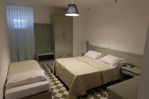a small bedroom with two beds and a cabinet at Hotel Baia Di Puolo in Massa Lubrense