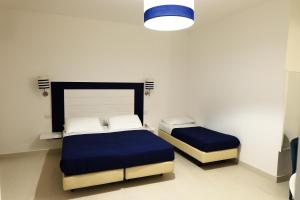 a bedroom with two beds with blue sheets at Hotel Baia Di Puolo in Massa Lubrense