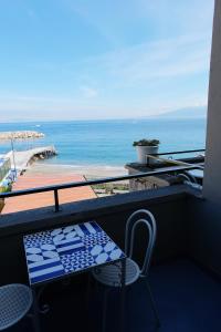 a balcony with a table and a view of the beach at Hotel Baia Di Puolo in Massa Lubrense