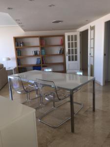 a glass table and two chairs in a room at apartamento ciudad de las ciencias in Valencia