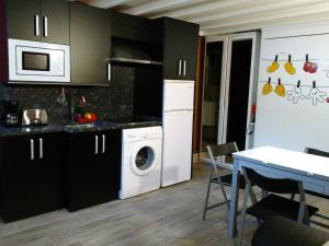 cocina con lavadora y mesa con sillas en Apartamentos Rurales Imaz Etxea - Urbasa, en Olazagutía