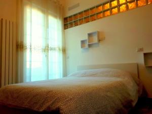 1 dormitorio con cama y ventana en Casa Magnolia, en Pomezia