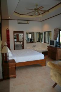 a bedroom with a bed and a tub and a television at Long Beach Inn in Sam Roi Yot