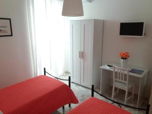 Schlafzimmer mit einem Schreibtisch und einem roten Bett in der Unterkunft Casa Marylisa in Bari